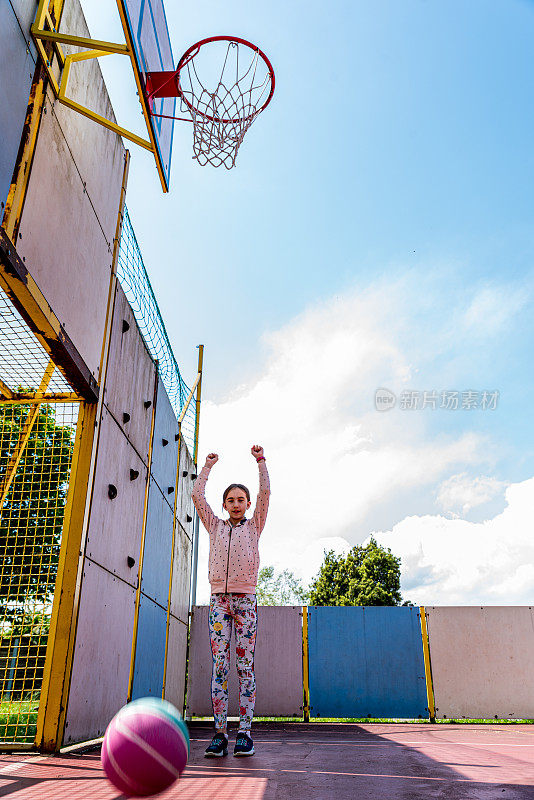 女孩独自在城市篮球场练习篮球