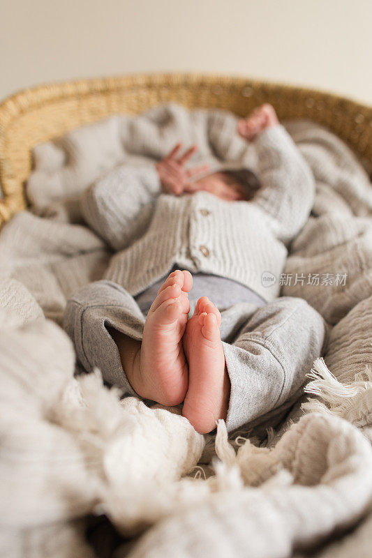 有12个脚趾“多指”的新生男婴躺在舒适的奶油棉毯子里