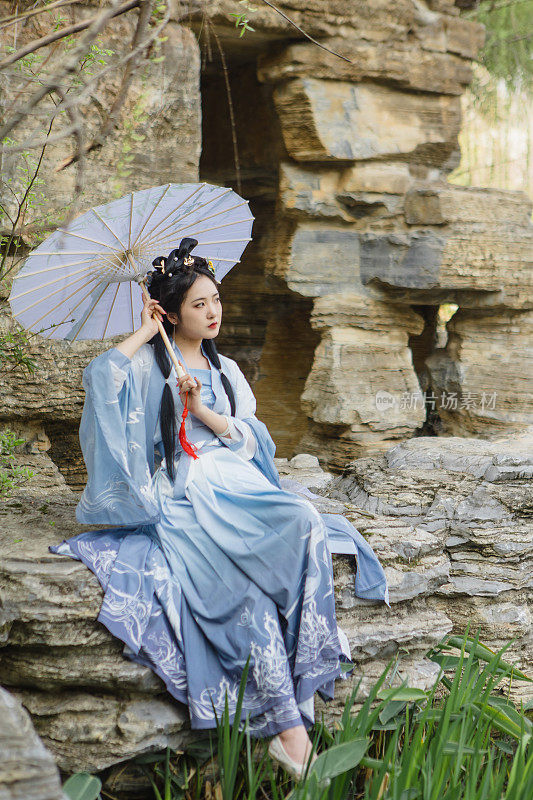 中国汉服美女在湖边撑伞