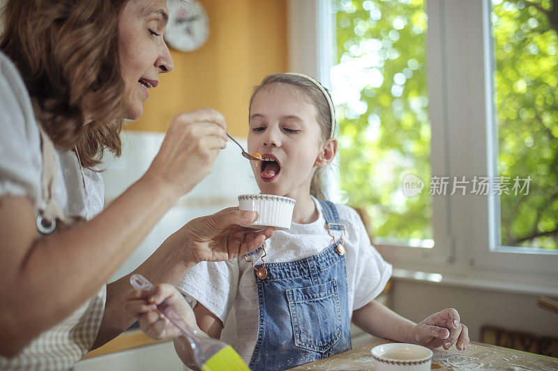 祖母给孙女一勺果酱。