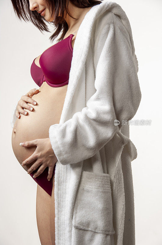 年轻的孕妇摸着她的肚子