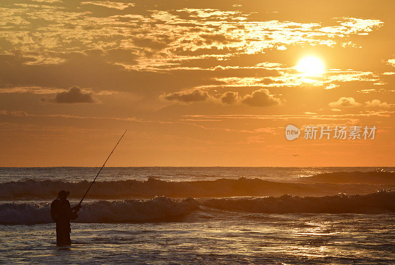 日落时大海里渔夫的剪影