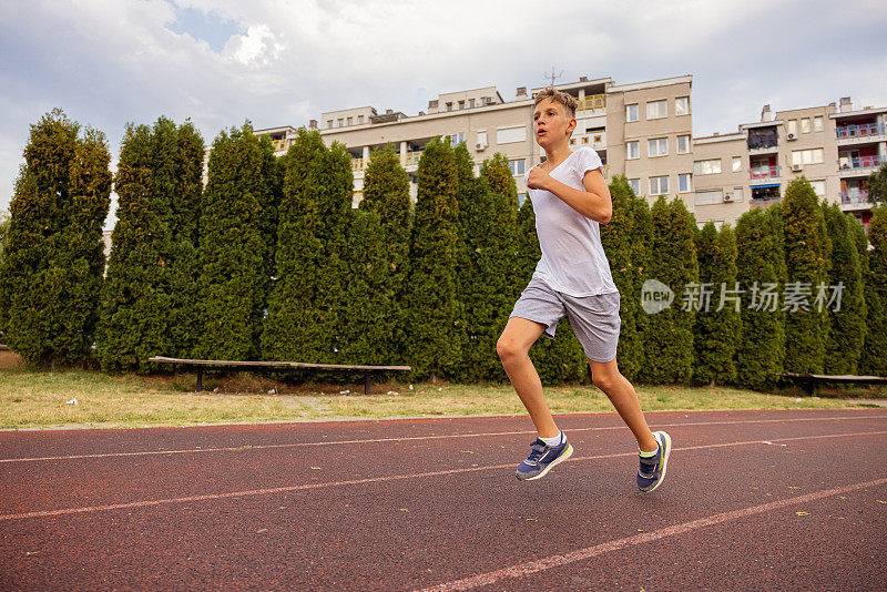 孩子在跑道上冲刺。全速奔跑。