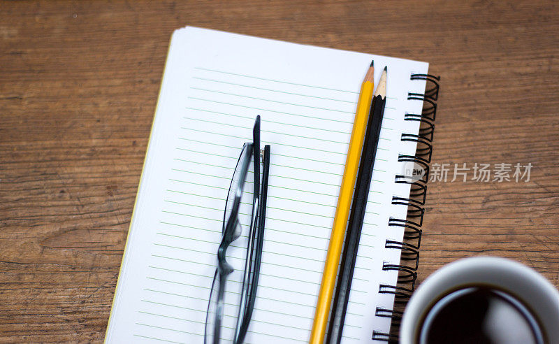准备工作:笔记本，咖啡，两支铅笔，眼镜，蓝绿色背景