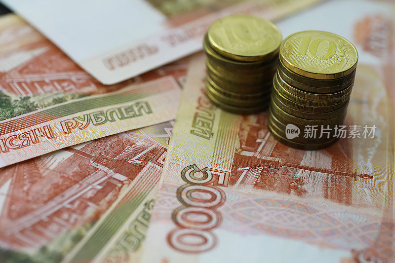 俄罗斯纸币和硬币“rubles”。印有“五千卢布”字样的纸币和5卢布和10卢布的硬币。背景是钱做的。