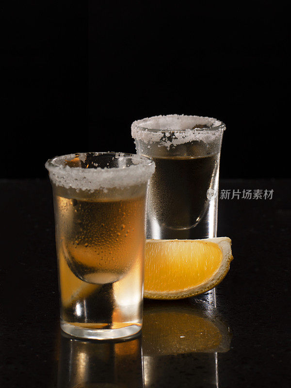 透明的龙舌兰酒酒与咸的边缘，片酸橙在优雅的玻璃杯