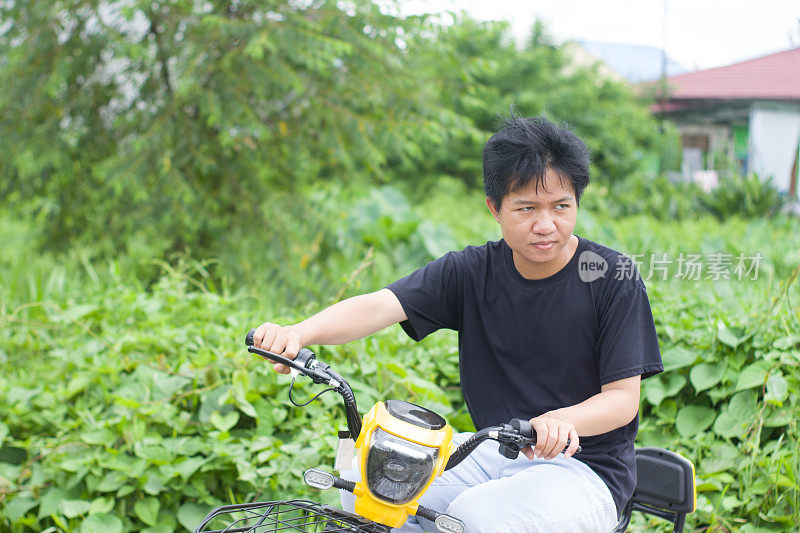 在居民区骑电动自行车的年轻人