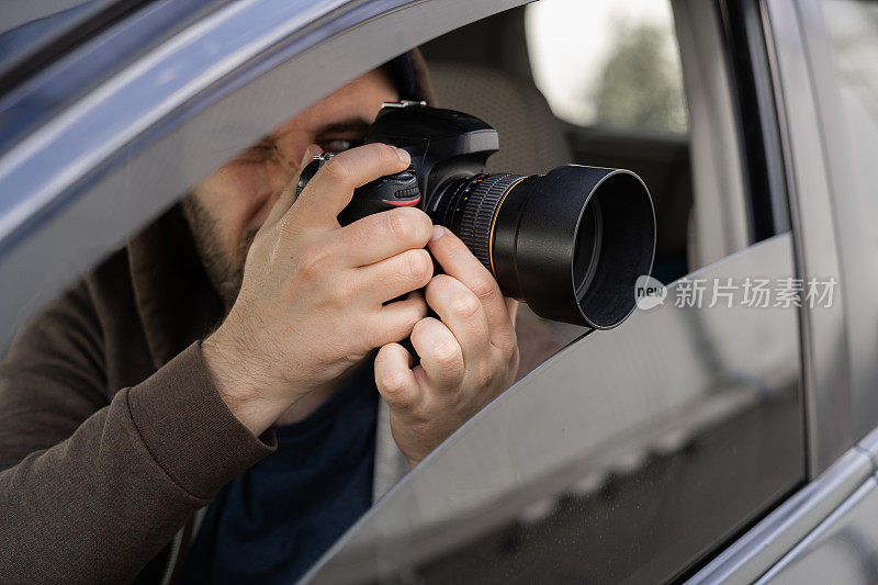 调查员或私家侦探，记者或狗仔队坐在车里，用专业相机拍照