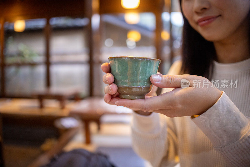 拿着一杯日本热茶的女人