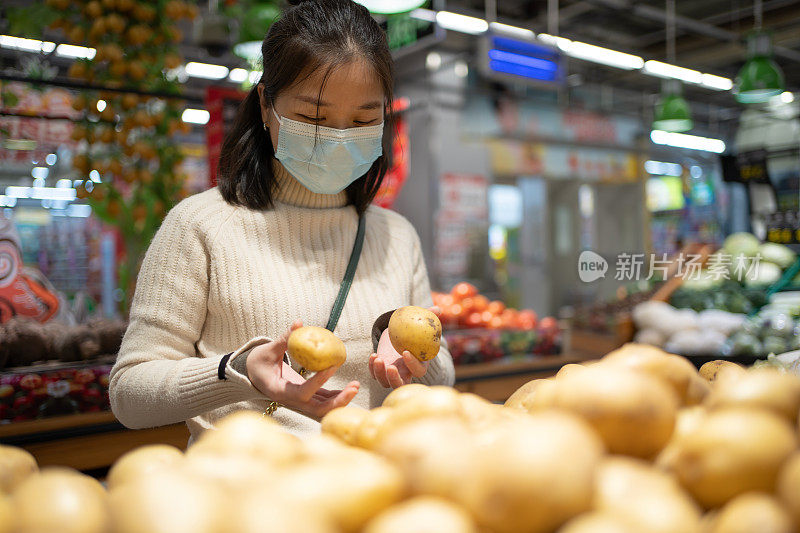 亚洲妇女正在摘土豆