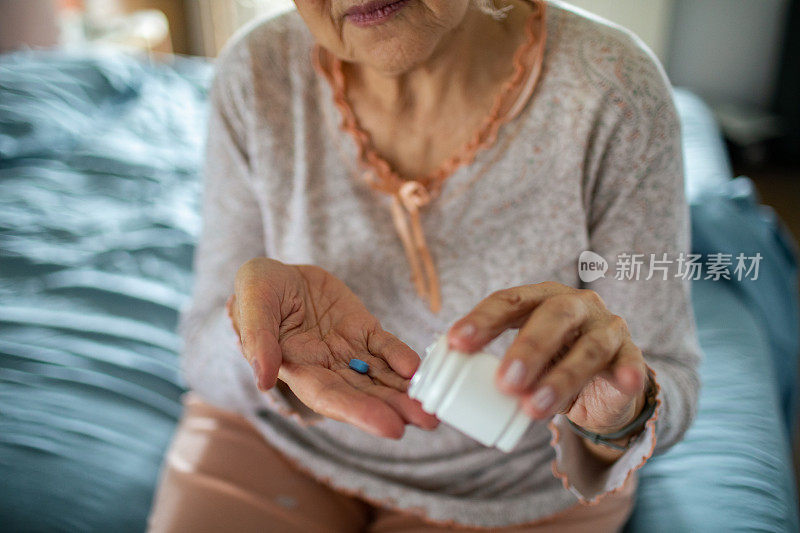 老女人在卧室里从药瓶里拿药