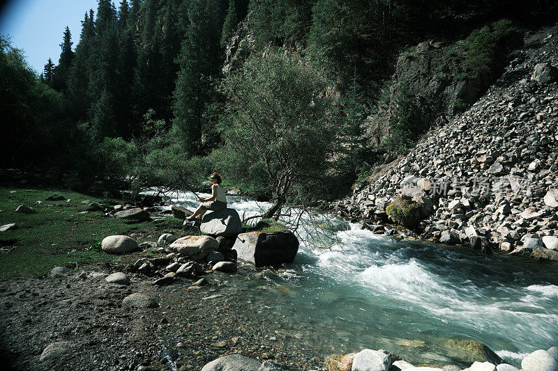 女游客正在展示南天山狭窄峡谷中的大山河
