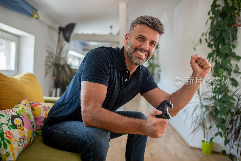 中年男子喜欢在家玩电子游戏