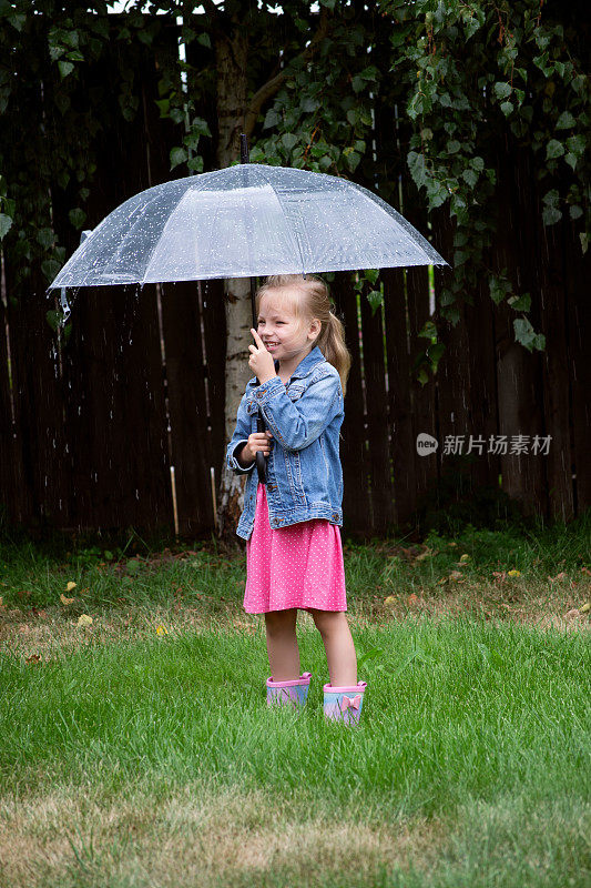 小女孩在雨中撑着伞