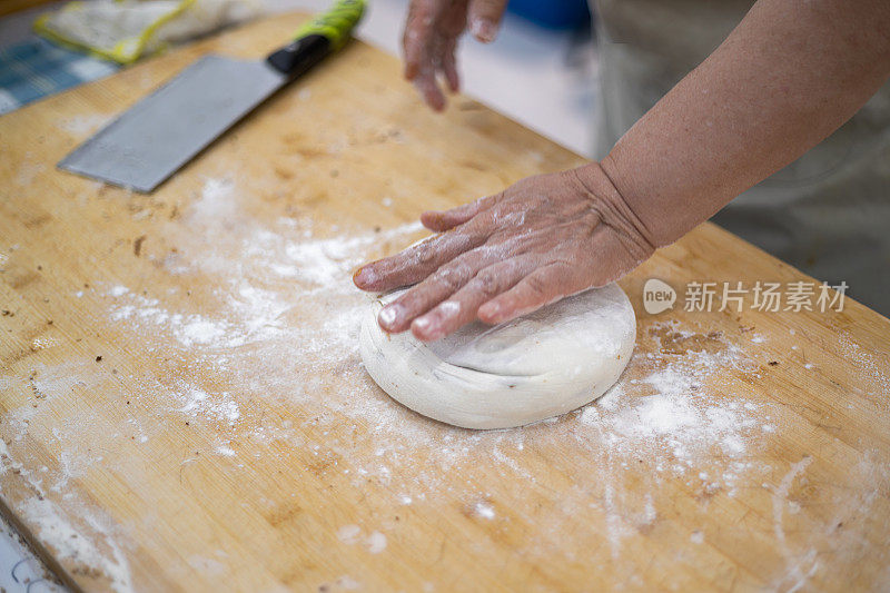 中国面食制作:中国芝麻面包。女人揉面团。制造碳水化合物食物的过程。