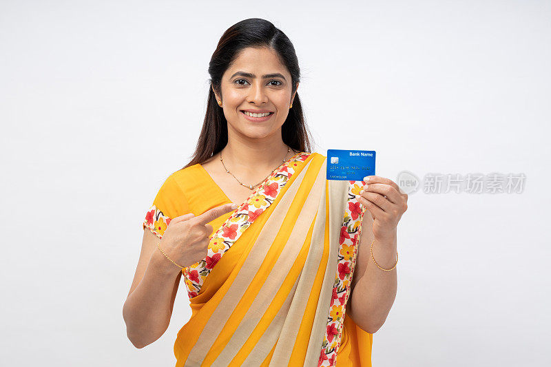 年轻快乐的印度妇女穿着纱丽的肖像，显示信用卡孤立在白色背景的股票照片