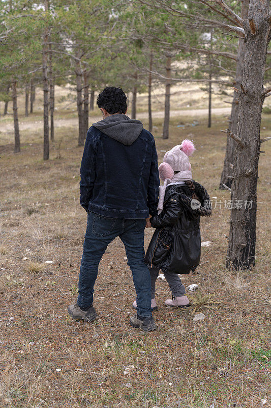 父亲和女儿在大自然中徒步旅行。