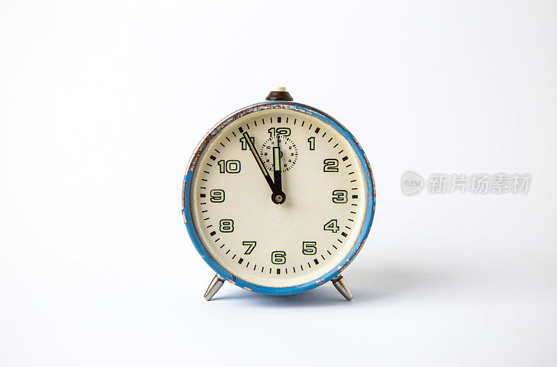 白色背景上的老式模拟蓝色时钟。那只钟显示的时间是从5分钟到12点。
