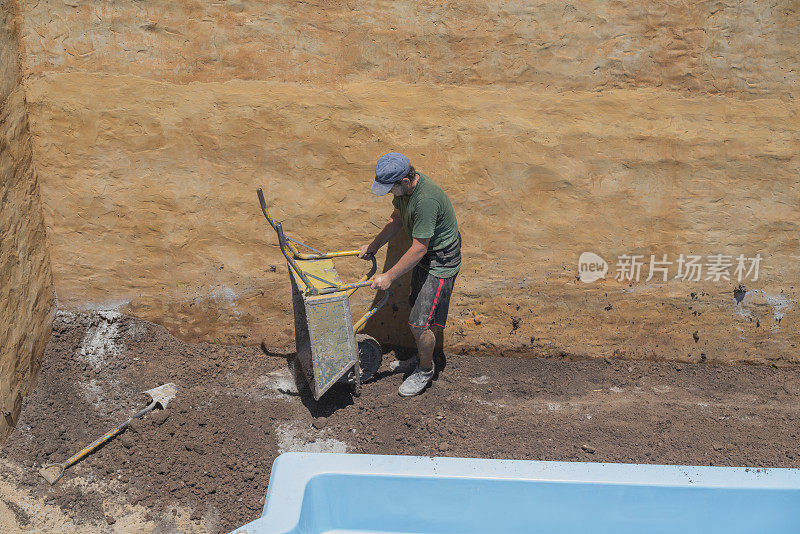 建筑工人在自家后院安装游泳池