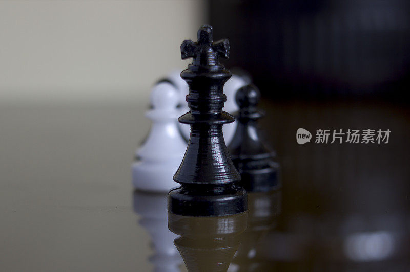 极端近距离微距拍摄的一个黑棋王站在黑棋和白棋兵显示领导概念