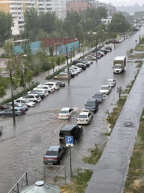 在一个大城市的街道上，雨后的洪水，一辆汽车驶过一个很深的水坑。