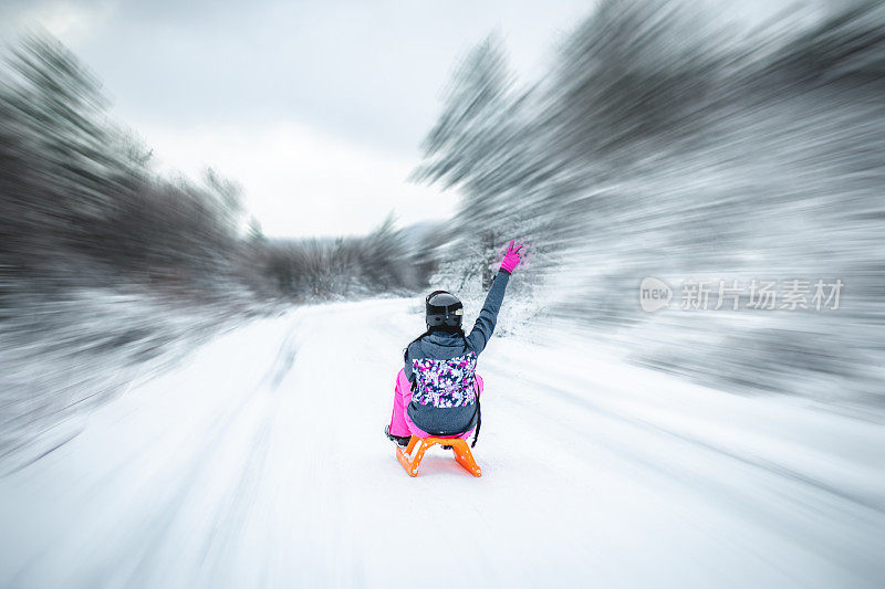 一对夫妻在雪地里滑雪，像孩子一样玩耍