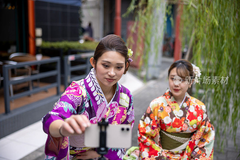 穿着和服的年轻女子在观光景点拍视频