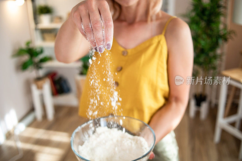 一位年轻女子正在家里准备披萨。网上食谱和食物准备。