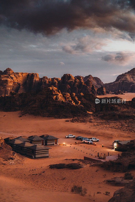 黄昏时分隐藏在瓦迪拉姆沙漠岩石中的贝都因人营地的风景