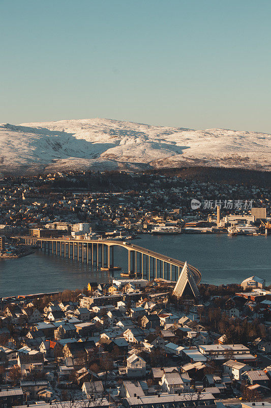 这是挪威北部的极地小镇特罗姆瑟，日落时背景中的雪山。这座巴黎北部的标志性建筑——挪威芬马克县的特罗姆瑟大桥