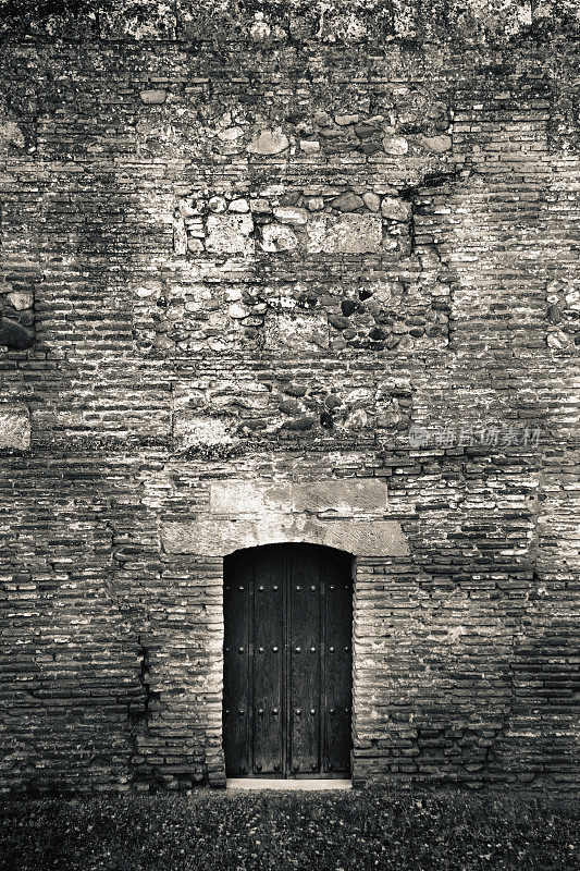 神秘的门在一个旧破墙,令人毛骨悚然,黑色和白色,地牢入口