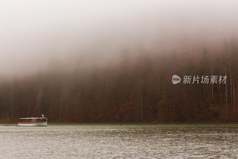 德国肯尼格湖上的雾。湖中央有小岛和游船。雾在湖岸上。德国的风景。秋景在欧洲贝希特斯加登国家公园。
