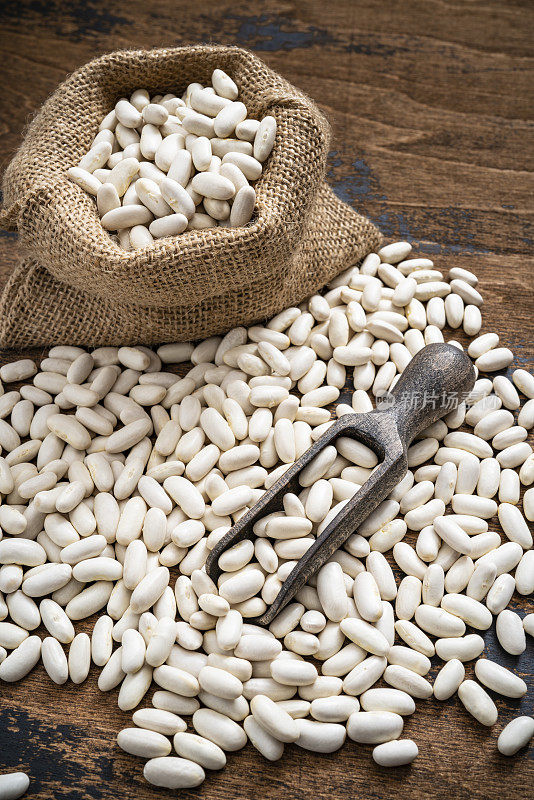 白豆干豆类在粗麻袋袋和木材服务勺乡村深色木材