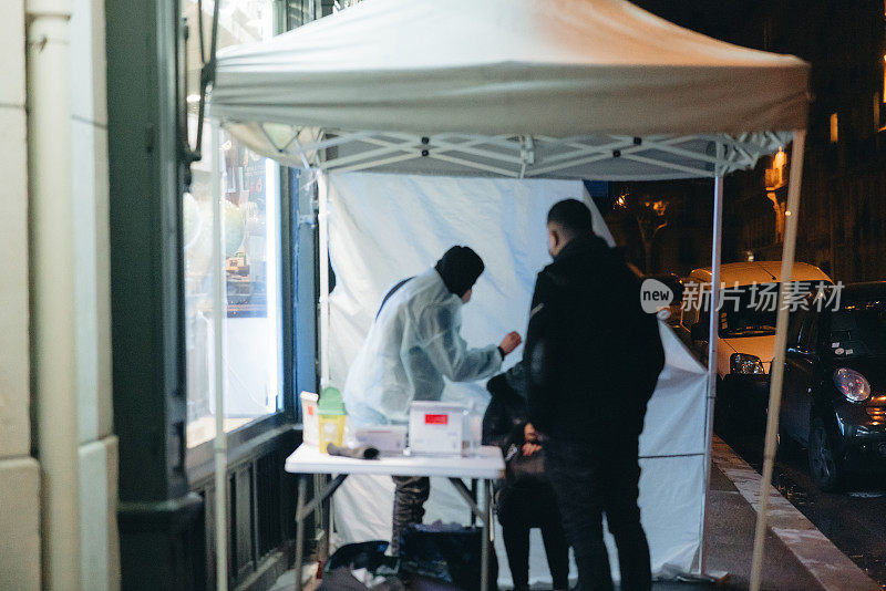 在巴黎街头的新冠病毒抗原检测中心，顾客在晚上接受检测