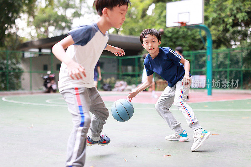 两个男孩在外面打篮球