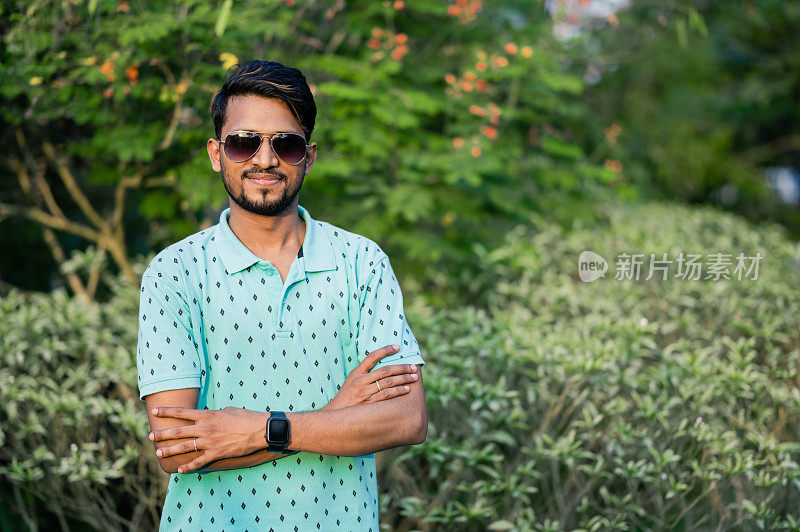 一个快乐的印度裔年轻人的肖像，在夏天戴着太阳眼镜
