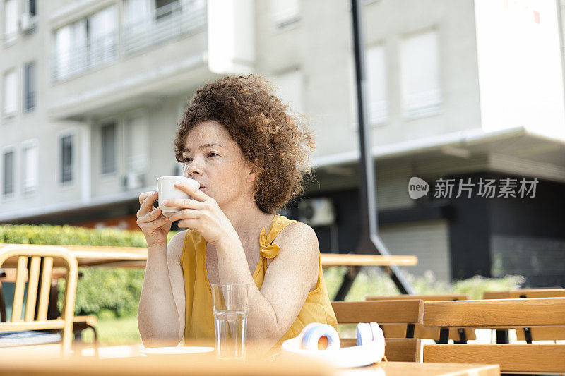 一名年轻女子在路边咖啡馆喝咖啡的肖像