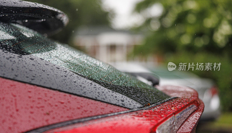 淋湿的车在雨中停在一个居民区。