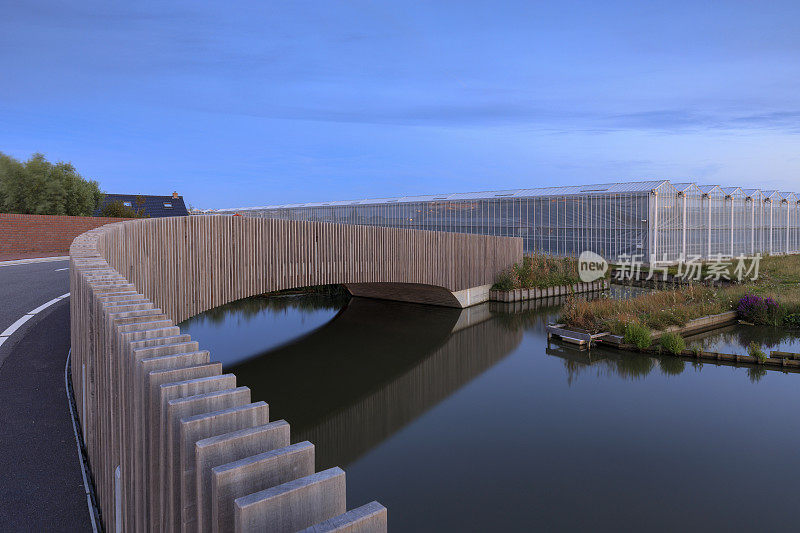 在荷兰一座农业温室旁边的一座现代步行桥