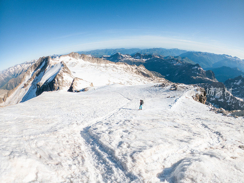 女登山者在雪道上攀登山峰