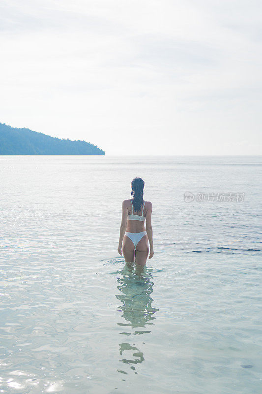 年轻女子涉水浅滩泻湖