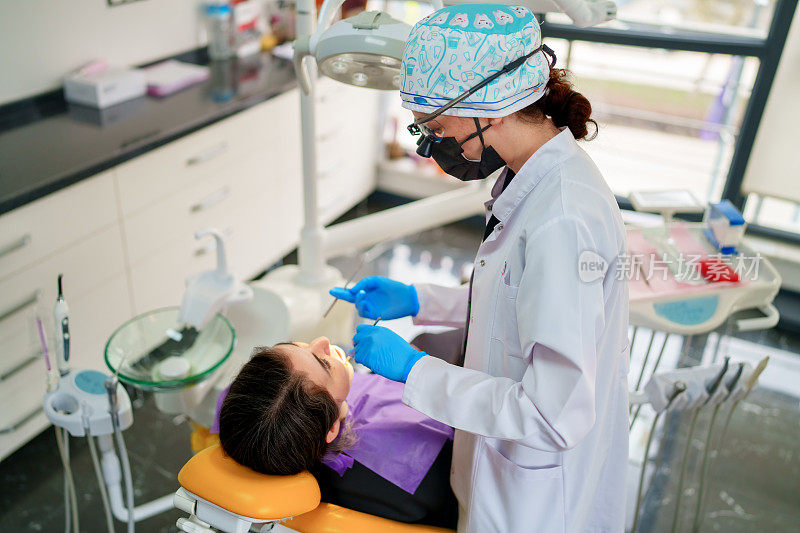 在牙科诊所为病人做口腔护理的女牙医