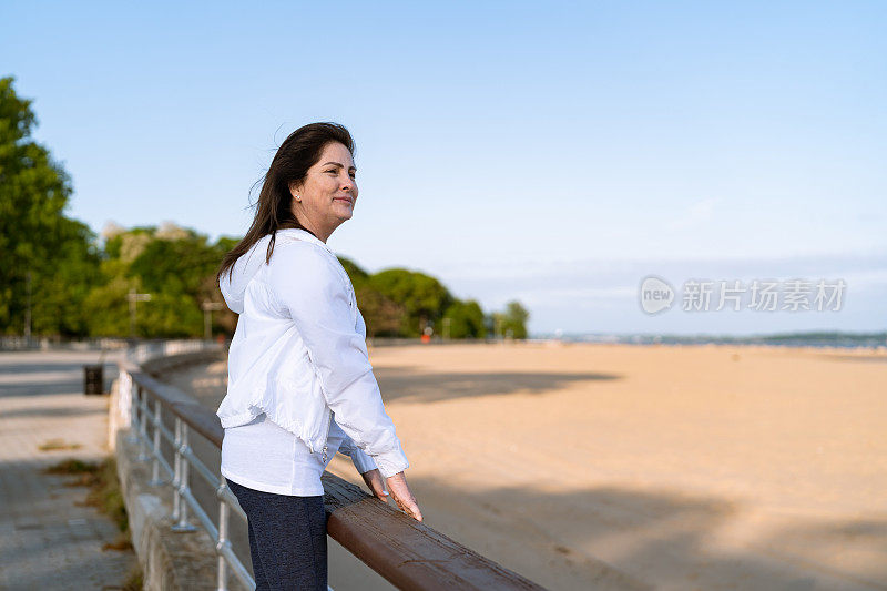成熟的拉丁女人看着远处的海滩
