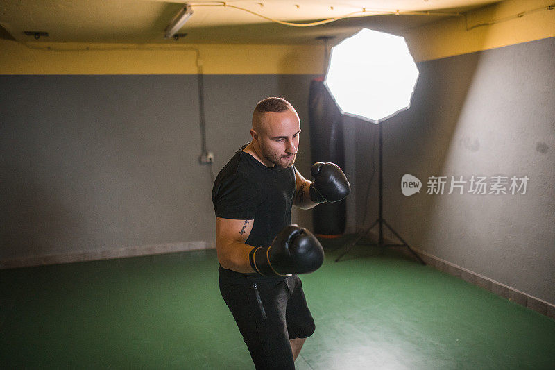 一个积极的男拳击手在健身房训练，为拳击比赛做准备