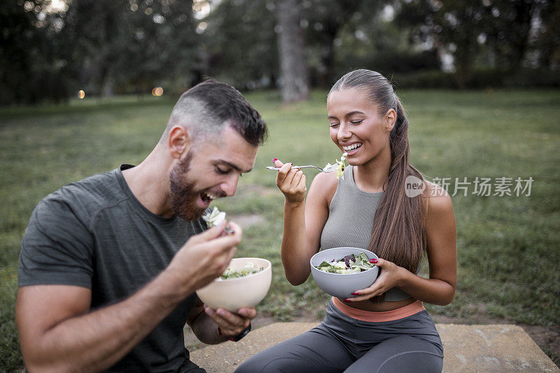 快乐的运动夫妇在剧烈运动后吃蔬菜沙拉