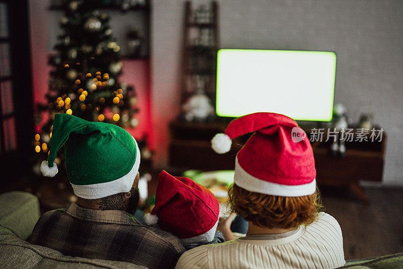 圣诞节时一家人在家里看电视的后视图——绿屏模型