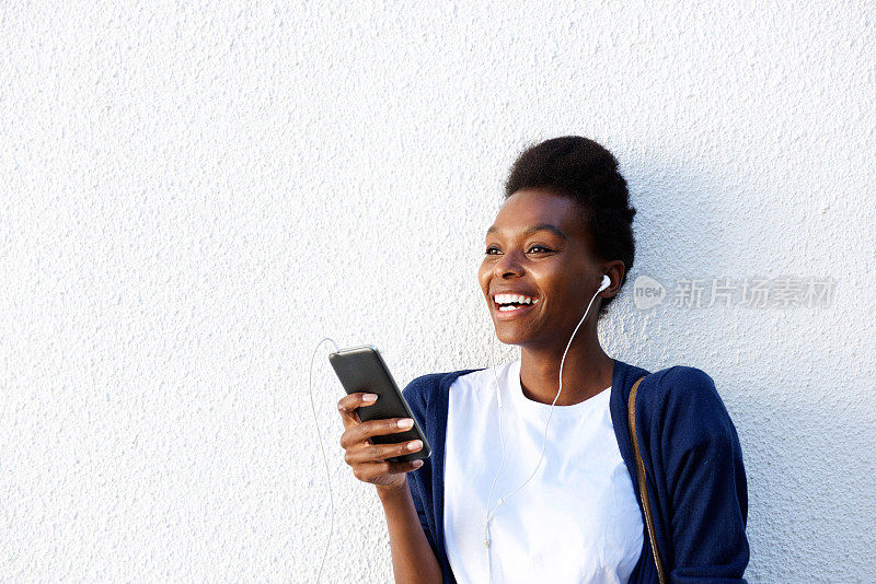 年轻的非洲妇女在智能手机上听音乐