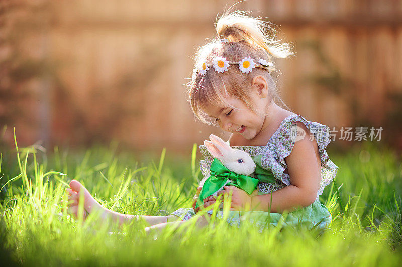 小女孩在草地上玩兔子