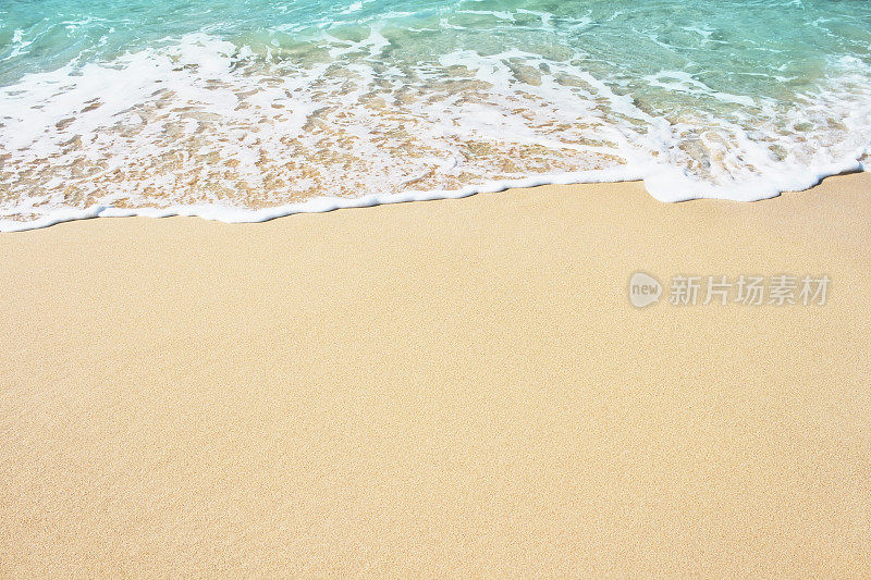 柔软的蓝色海浪在沙滩上。
