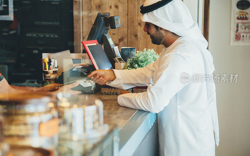 一名阿联酋男子在咖啡馆用信用卡付账